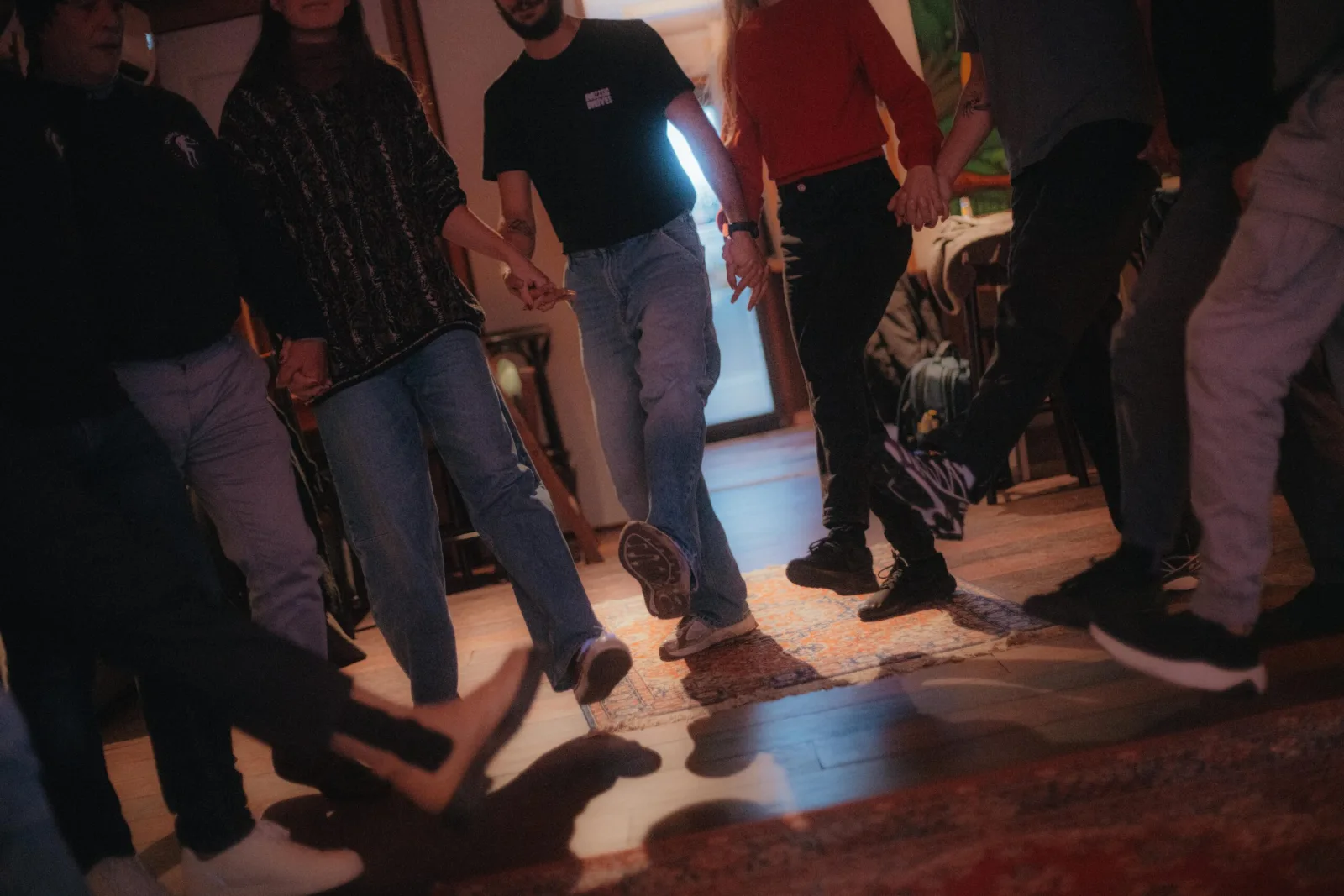Deelnemers dansen samen in een kring tijdens een Embrace-avond